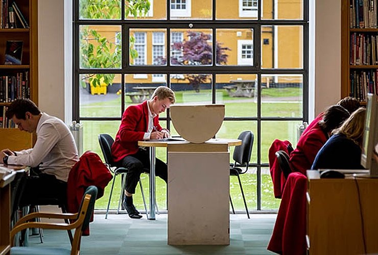 Loretto School students learning at tables in the school's library