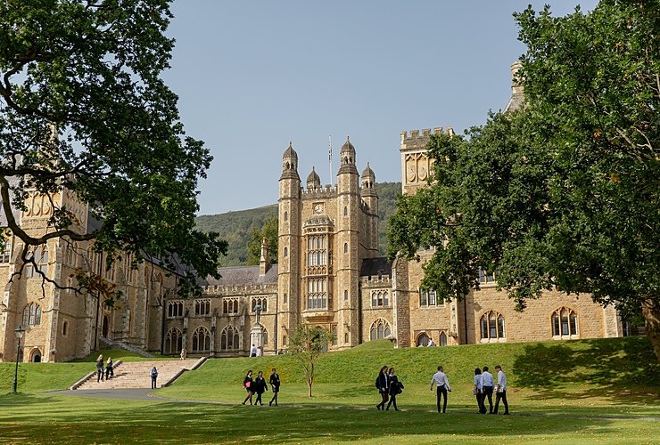 The stunning campus of Malvern College with pupils walking in front in the afternoon