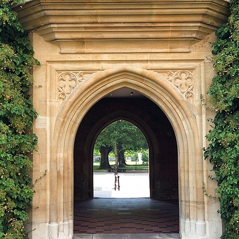 Old gate in yellow brick with garden at the end