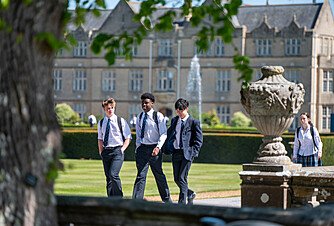 Pupils walking along Canford School campus in sunny weather