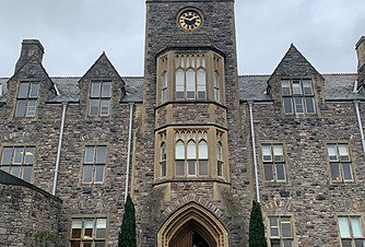 Historic stone school building with clock tower