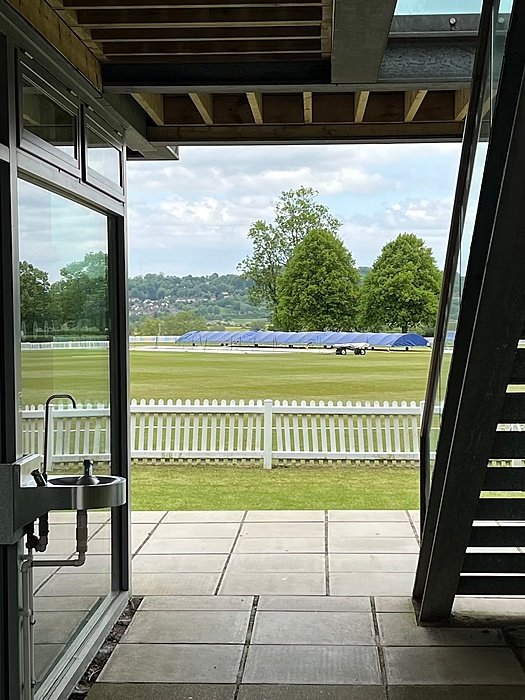 Looking onto sports fields, infront is a white fence,