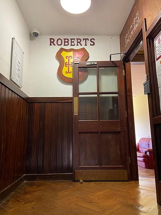 Hallway with open door and crest on the wall