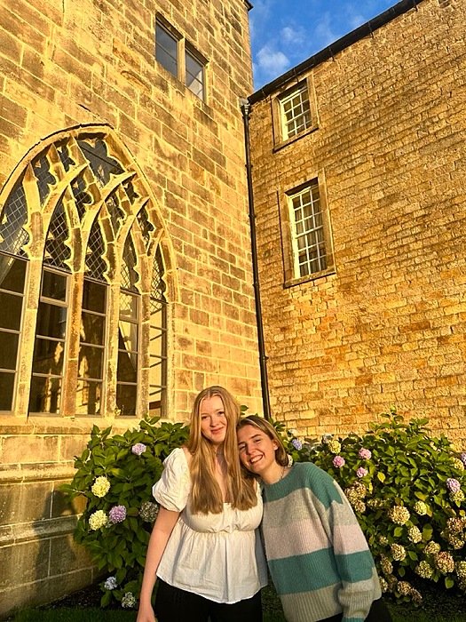 Two girls in front of old building in the sunshine