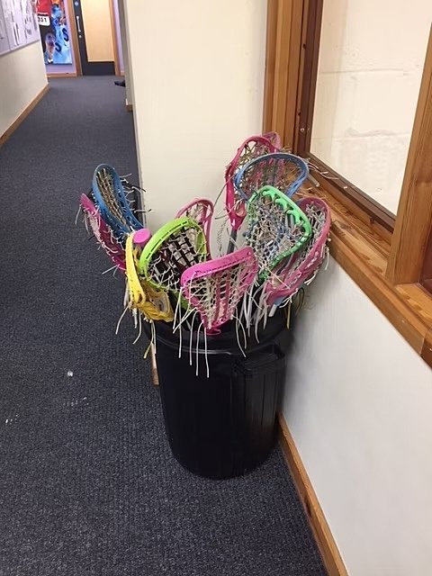 Hallway with black bucket and colourful Lacrosse rackets