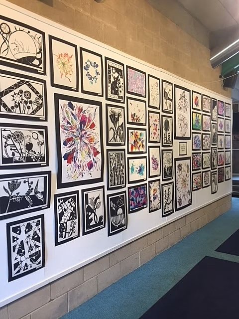Wall with a lot of art, glued onto black frames
