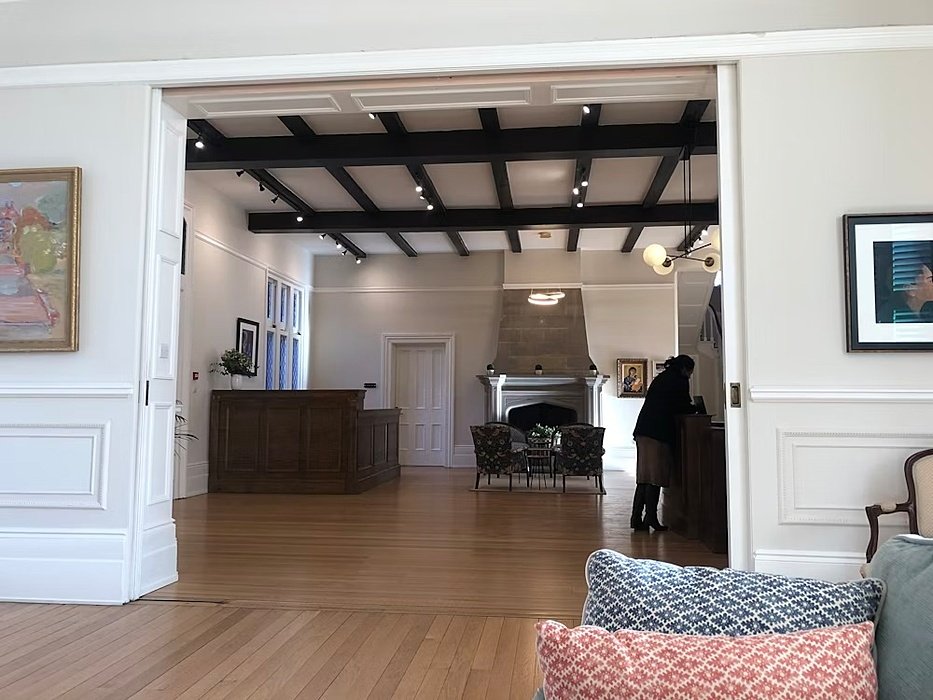 White room that opens into a second room, reception table, dark beams