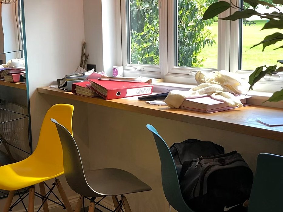 Colourful chairs and working material on a window table