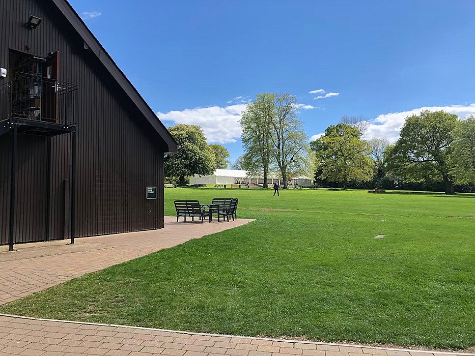 Green, outdoor chairs and half of a barn-looking house