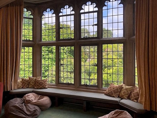 An alcove with cushions and a view into a green park