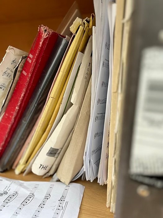 Folder and books with music notes in a shelf