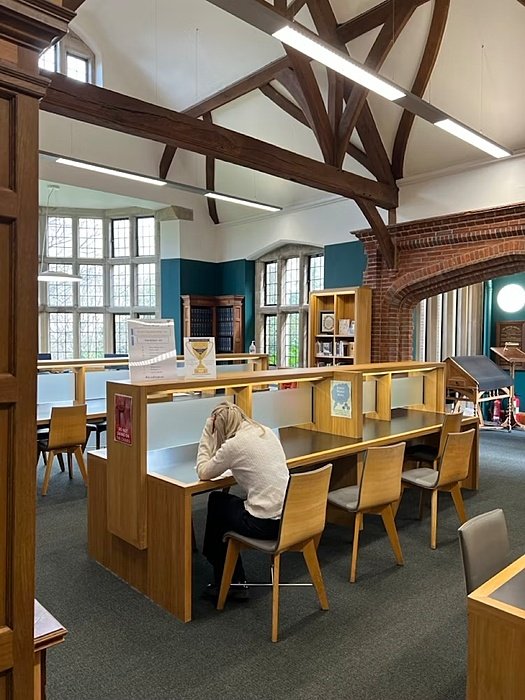 A female student during her studies at a desk in the school Library