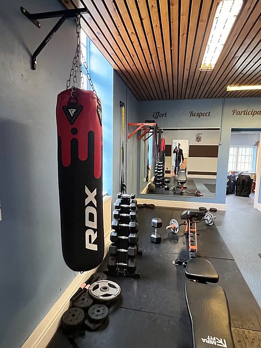Gym with a punch bag, weights and weight training bench