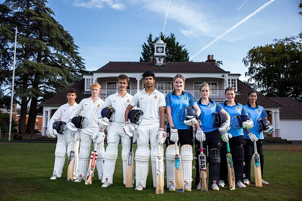 A mixed Cricket team smiling into the camera for a team shot