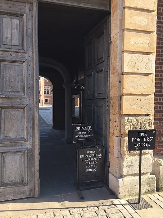 Entrance gate with wooden doors and signs indicating that Eton College is closed to the public.