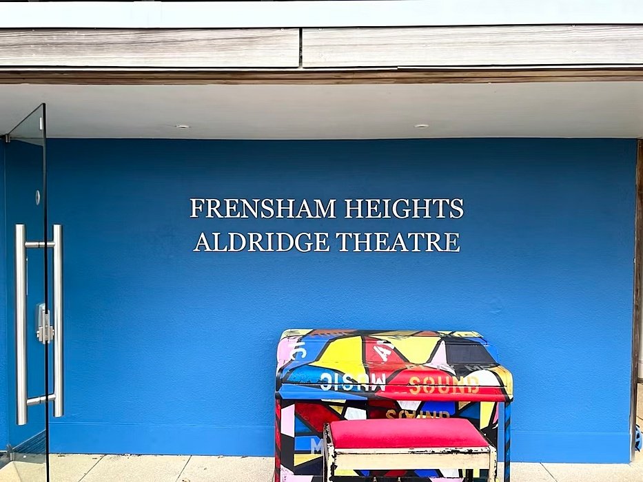 Colourful piano infront of a blue wall