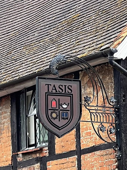 Logo of the TASIS School infront of a brick wall