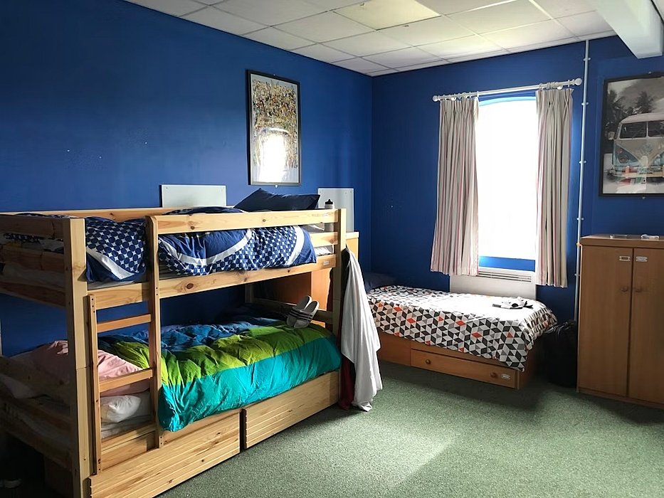 A triple boys room with bunkbed and blue coloured walls