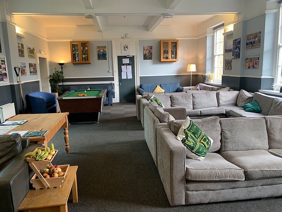 Boarding house common room with sofas and a pool table