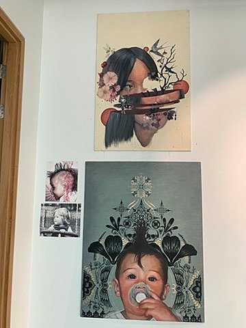 Portrait paintings of women and children on white wall display