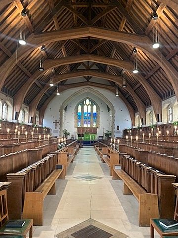 Wooden chapel interior with arched ceiling and long pew rows