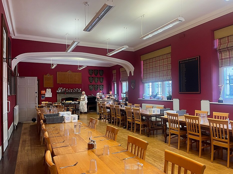 Dining hall with long wooden tables at British boarding school