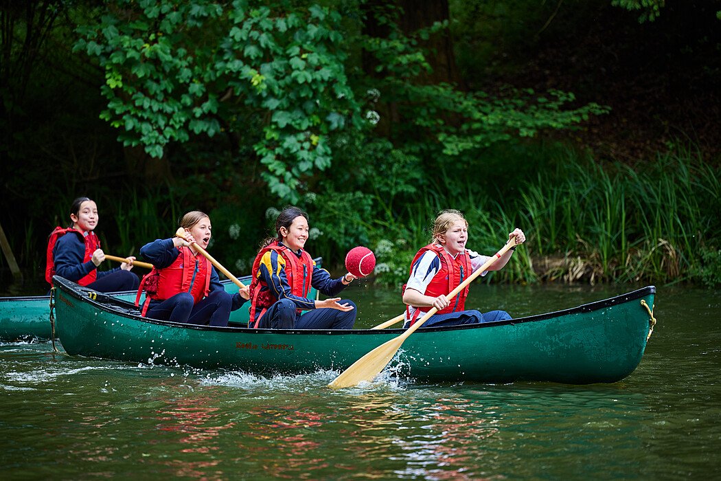 Four Christ's Hospital students in a canoe on the water