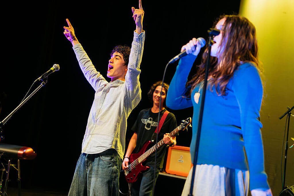 Students performing music together on stage at Charterhouse School