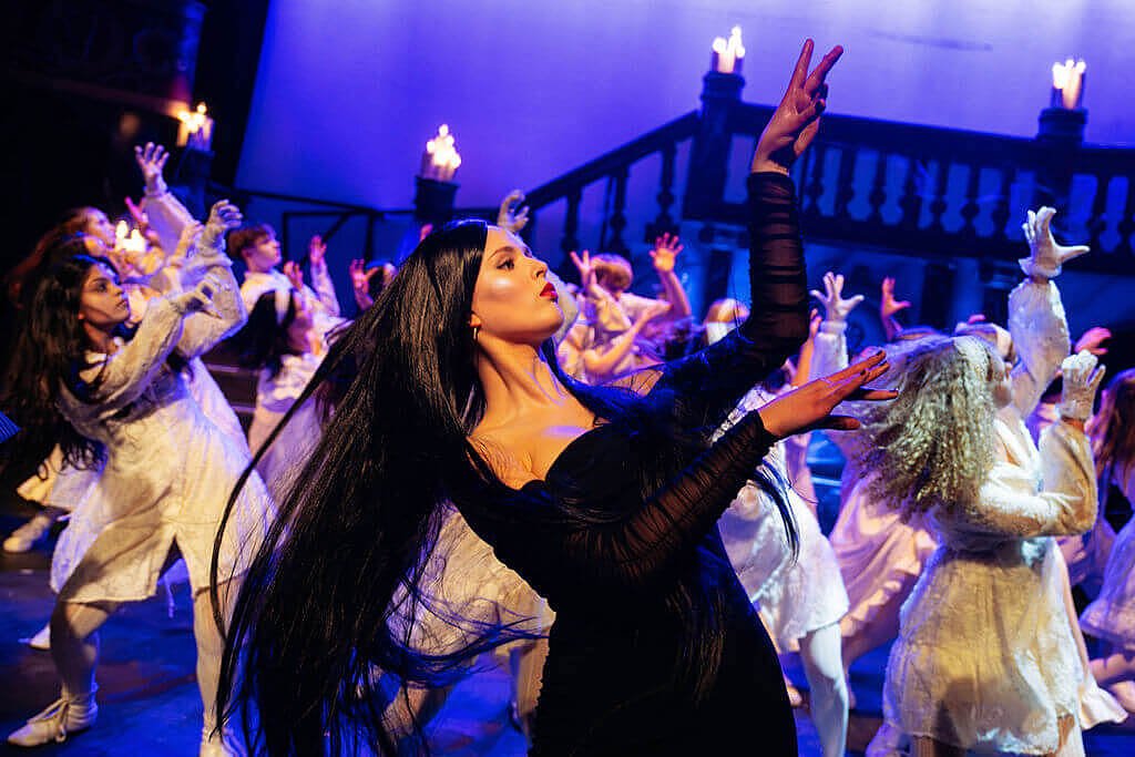 Students performing a musical theatre show on stage.