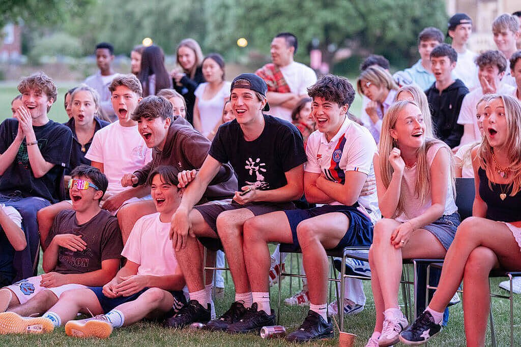 an audience of Charterhouse students is laughing and enjoying a piece of entertainment
