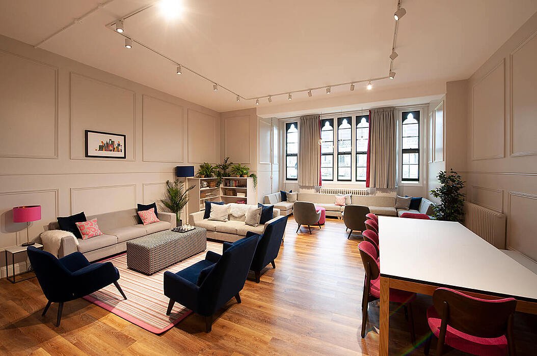 Common room with sofas and study tables in boarding house