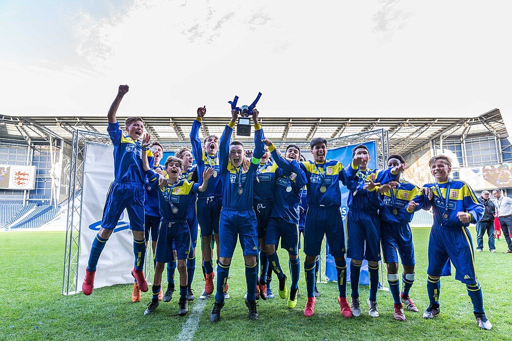 Claremont School Football team celebrating their win and lifting their cup