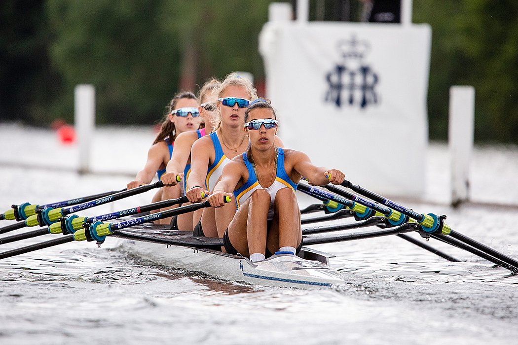 Girls rowing team training on river during school sports session