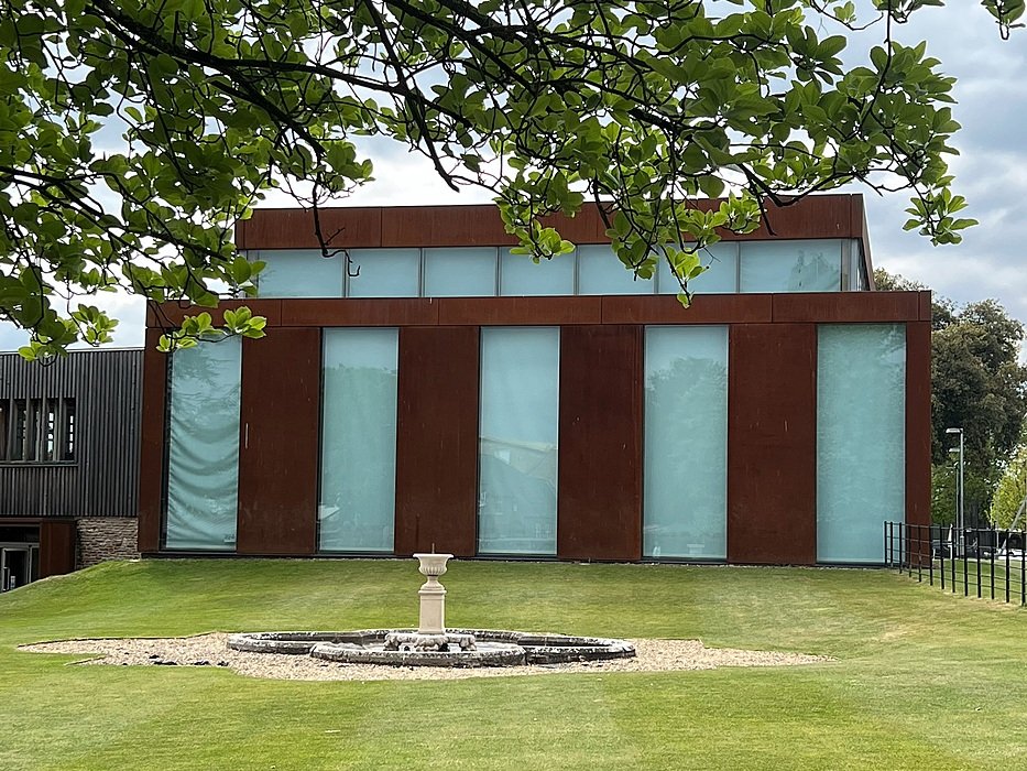 a modern school building with blinds down on big floor to ceiling windows