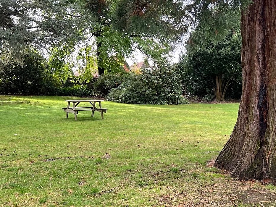 A garden bench and table on the school lawn at KESW