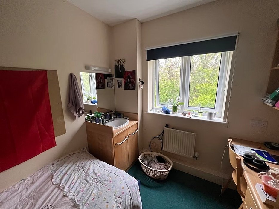 Single room with bed and sink and table