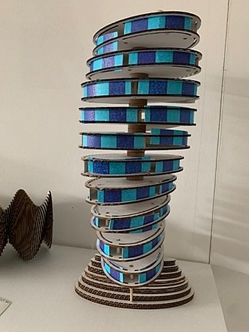 Spiral tower model made from blue glass panels and wood