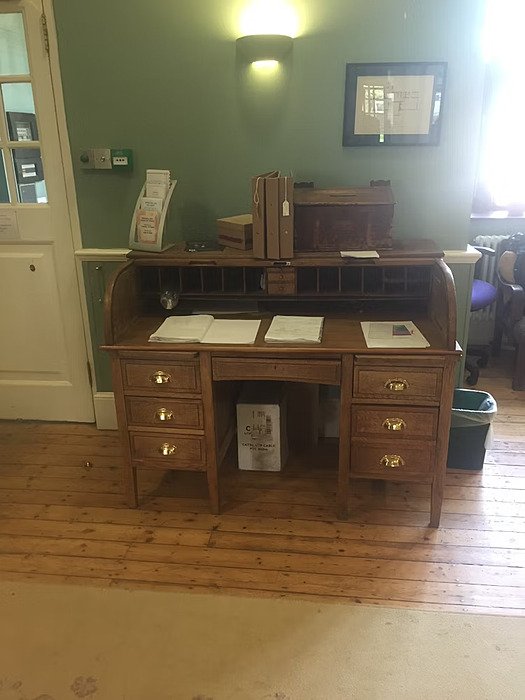 Old desk infront of green wall