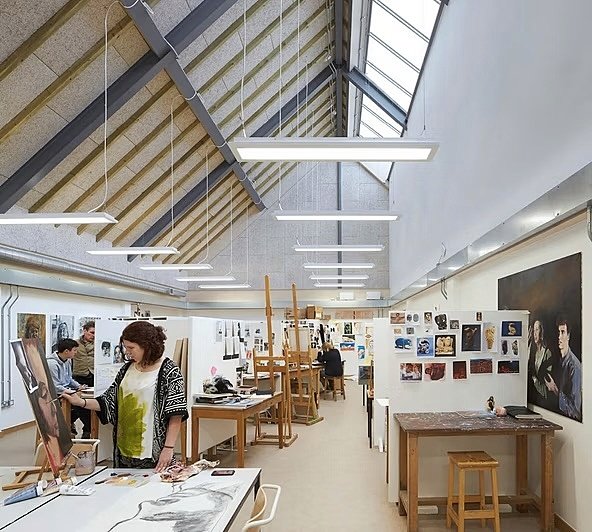 Bright Art studio, canvases, tables, easles, people