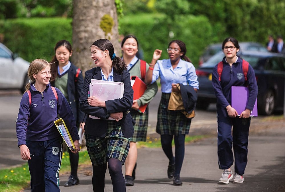 Six school girls laughing on their way