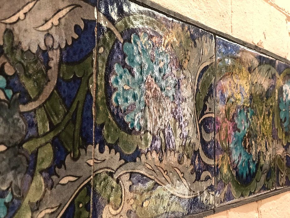old painted stones on a stonewall in blue and green colours