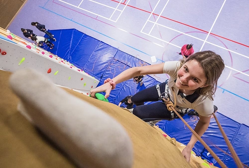Climber going up an indoor climbing wall