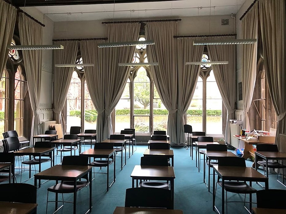 Classroom with blue carpet and long curtains in a historic room