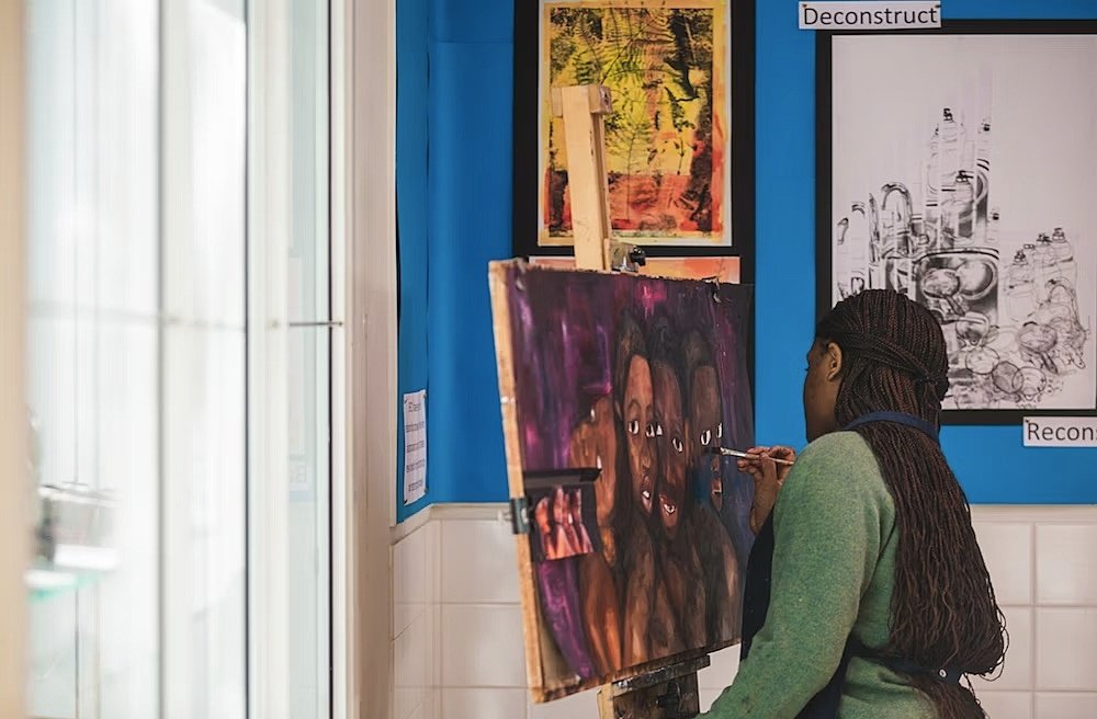 Girl painting a canvas with faces
