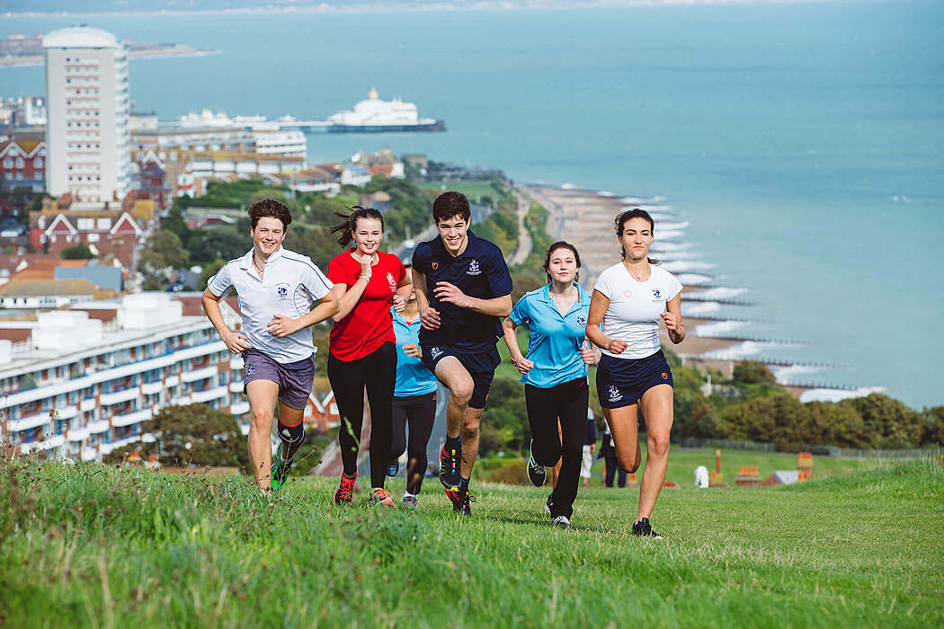 Students from a UK boarding school running by the seaside during sports training