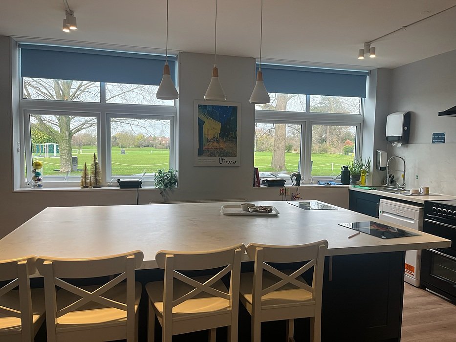 Bright common-room kitchen at St Edward’s Oxford with large table and campus view.