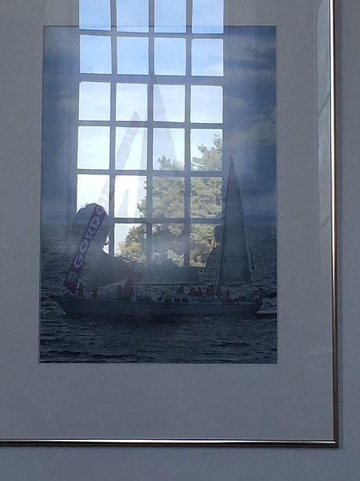 A photo on the wall, reflecting the window and shows the sailingboat with the veil "Gordonstoun"