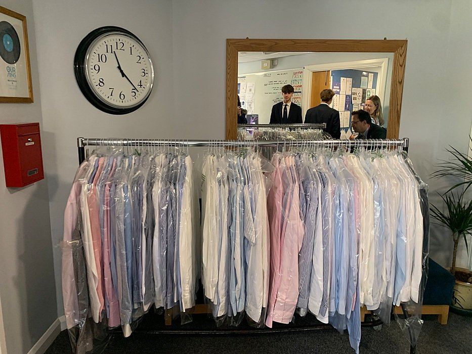 School uniform shirts neatly arranged on a clothing rack in a British boarding school.