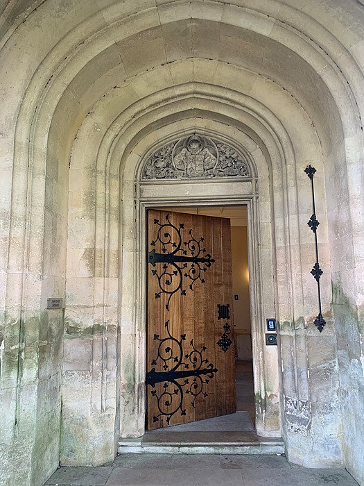Historic entrance with heavy wooden door, wrought iron details and stone archway