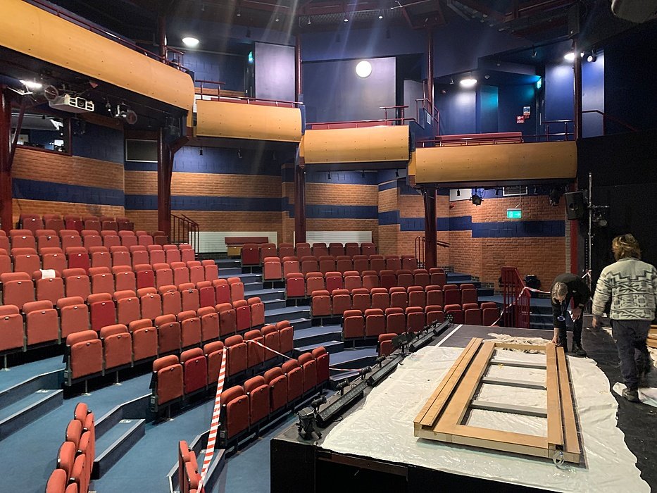 Theatre auditorium with red seating, stage and modern interior design